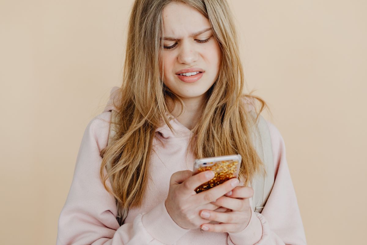 A teenager looking at a phone, the way the Cat in the Hat AI school threats spread