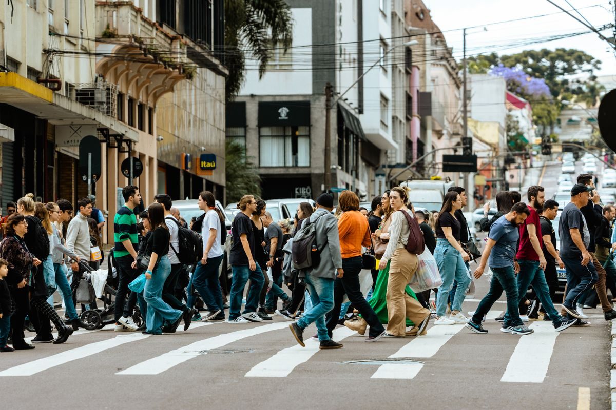 A crowd of people crossing a busy city street