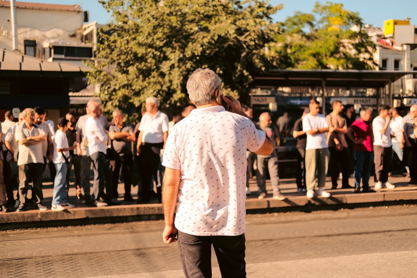 People waiting at a sunny bus stop, representing the staged rollout of unlimited text chats